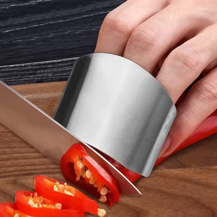 SafeSlice finger guard protecting hand while slicing vegetables on a chopping board